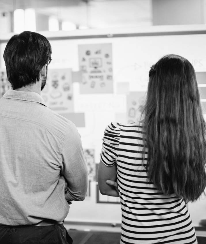 Projektboard - zwei Projektteilnehmer stehen vor einem Projektboard