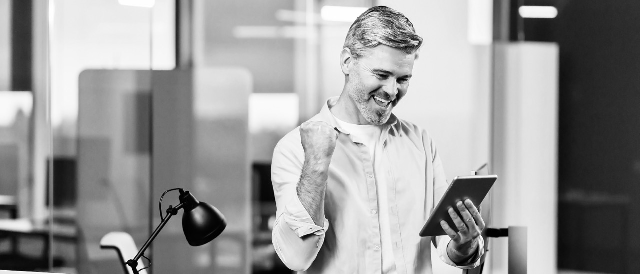 User Adoption - ein Mann arbeitet begeistert mit einem Tablett